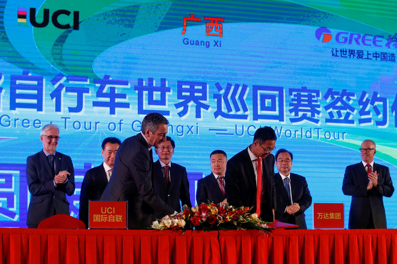 © Reuters. Wanda Group Chairman Wang, UCI President Cookson, Guangxi autonomous region official Lan Tianli and Wang Jingdong of Gree Electric Appliances attend a signing ceremony for a China hosted UCI world tour cycling race in Beijing