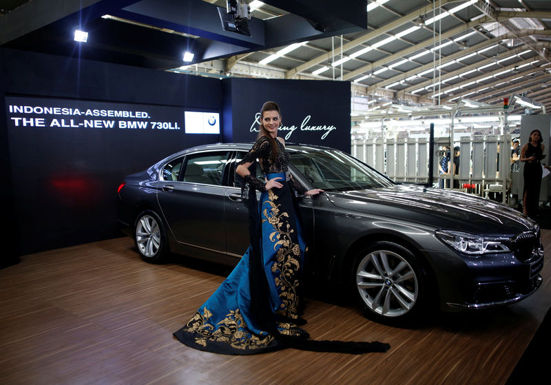 © Reuters. A model poses next to a BMW 7 Series car assembled locally during a media launch at a Gaya Motor assembly plant in Jakarta, Indonesia