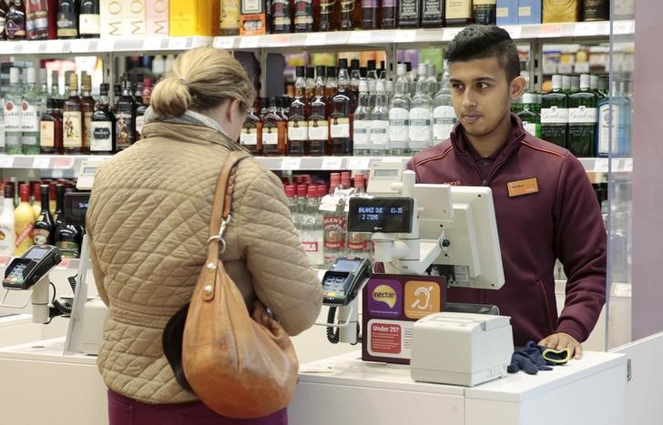 © Reuters. An employee works at a till in a Sainsbury's Local store in central London