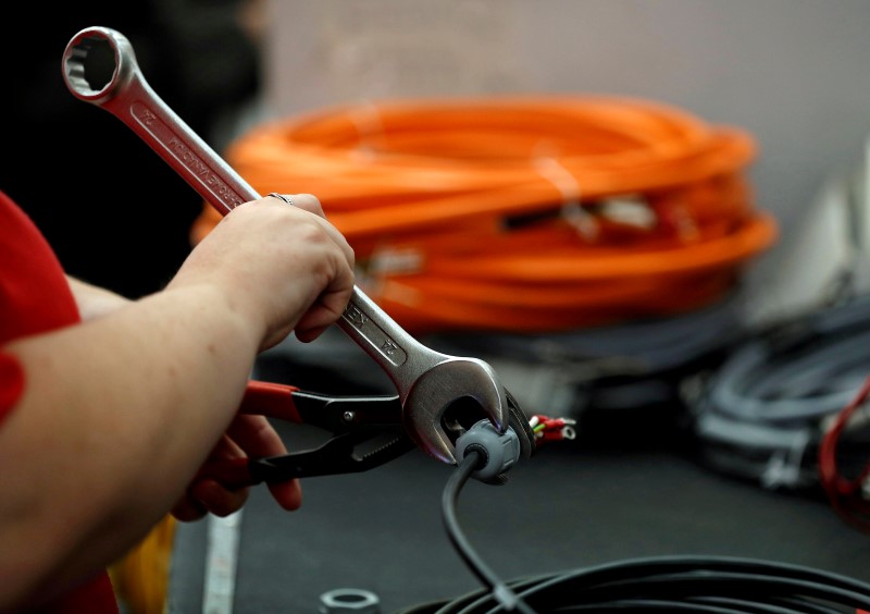 © Reuters. A worker attaches a connector to electrical wire on the factory floor of PP Control and Automation near Cannock