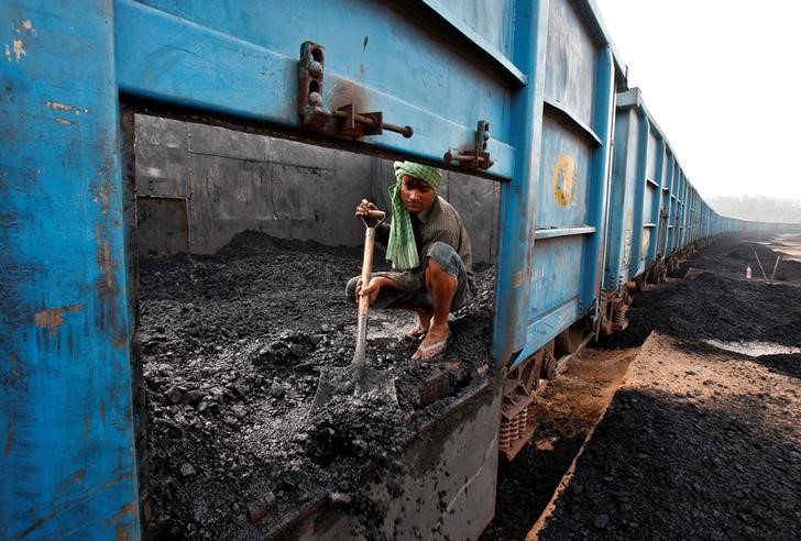 © Reuters. Worker unloads coal from a goods train at a railway yard in Chandigarh