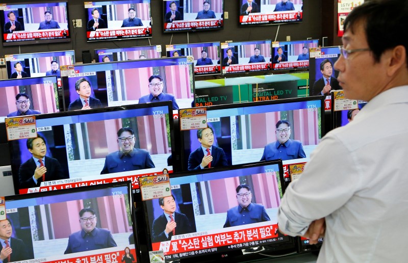 © Reuters. A sales assistant watches TV sets broadcasting a news report on North Korea's fifth nuclear test, in Seoul