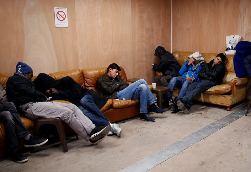 © Reuters. Migrants rest in the common area at the reception center for migrants and refugees near porte de La Chapelle in the north of Paris