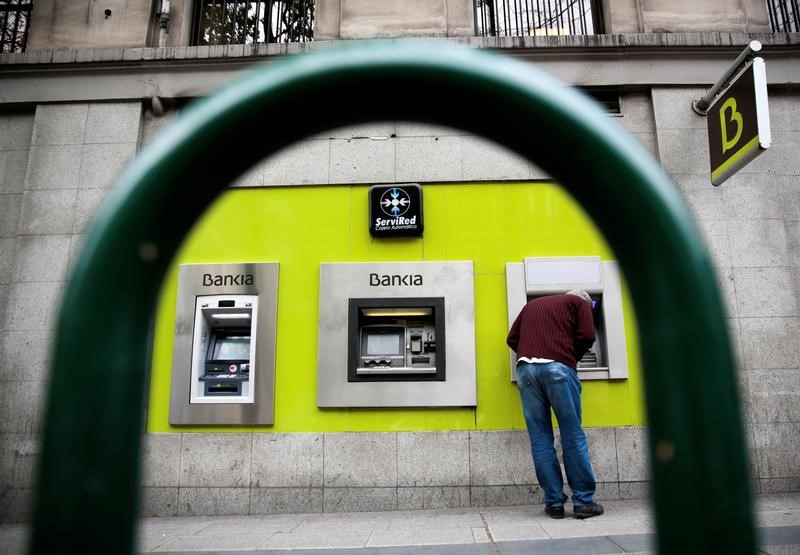 © Reuters. A man uses a cash dispenser at a Bankia branch in Madrid