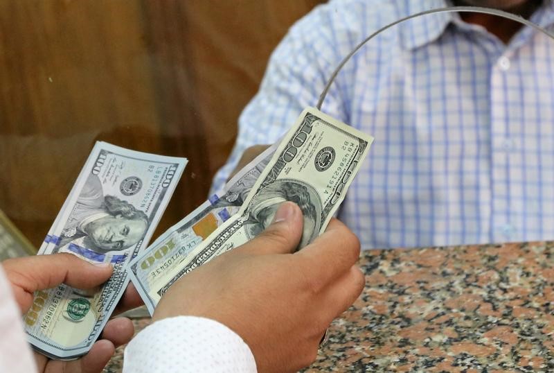 © Reuters. Cliente troca notas de dólar em casa de câmbio no Egito