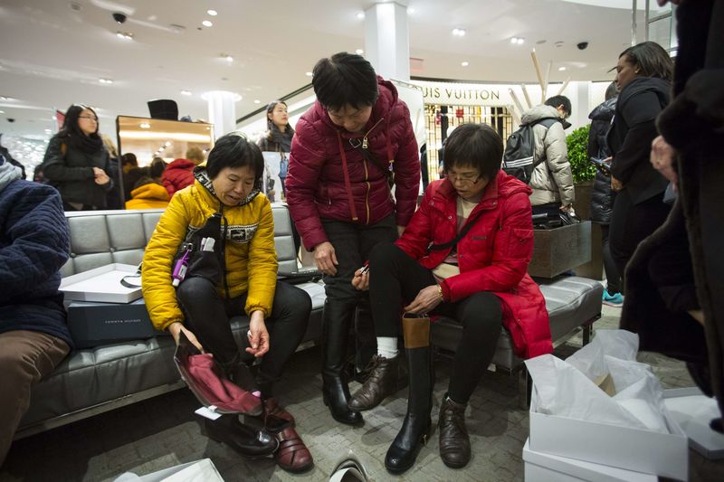 © Reuters. Women try on shoes in Macy's to kick off Black Friday sales in New York