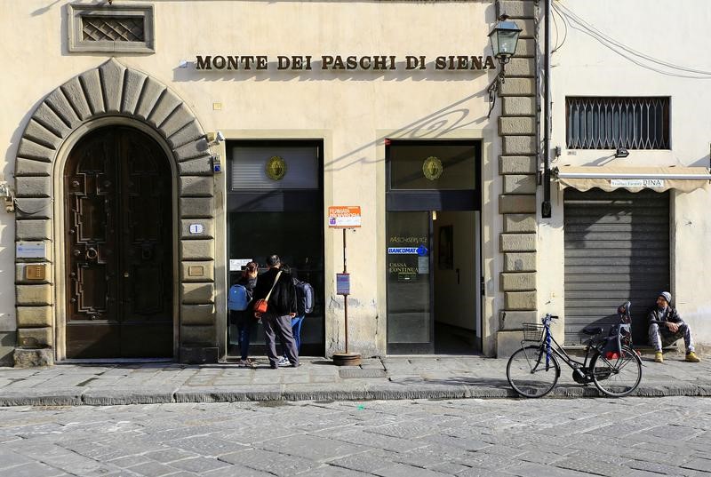 © Reuters. People use a cash machine of Monte Dei Paschi bank in downtown in Florence