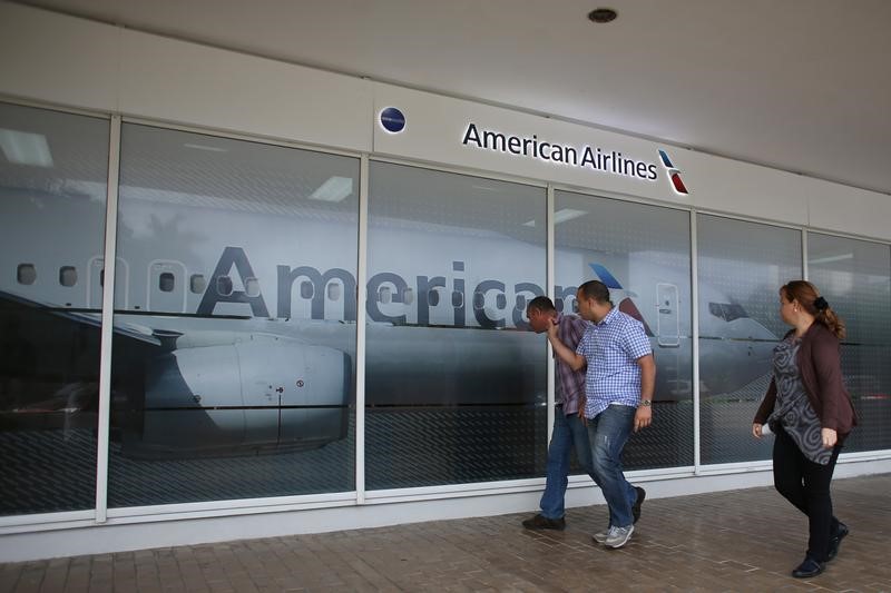 © Reuters. People walk past an American Airlines office, which is not operational yet, in Havana, Cuba