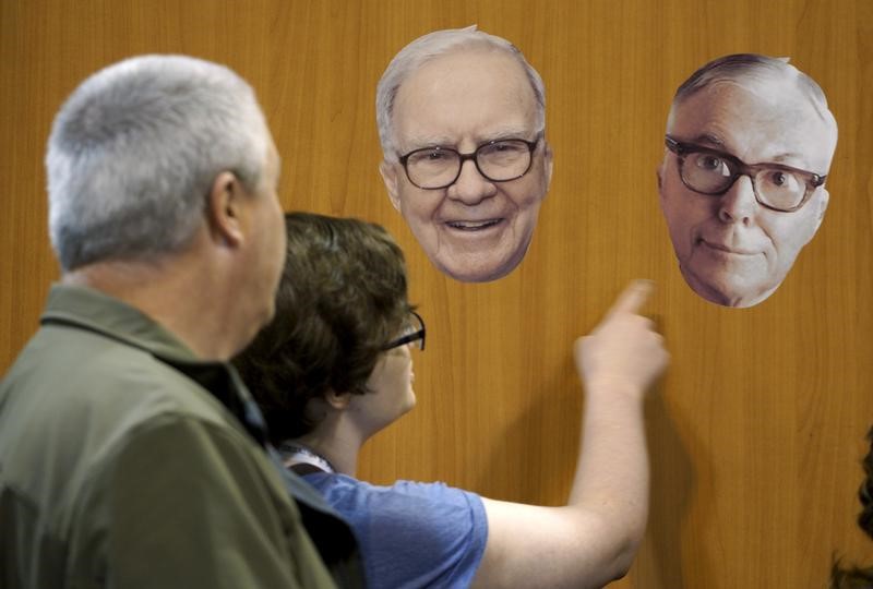 © Reuters. Berkshire Hathaway shareholders look at photos of Berkshire CEO Warren Buffett and vice-chairman Charlie Munger at the Berkshire-owned Fruit of the Loom booth at the shareholder's shopping day in Omaha