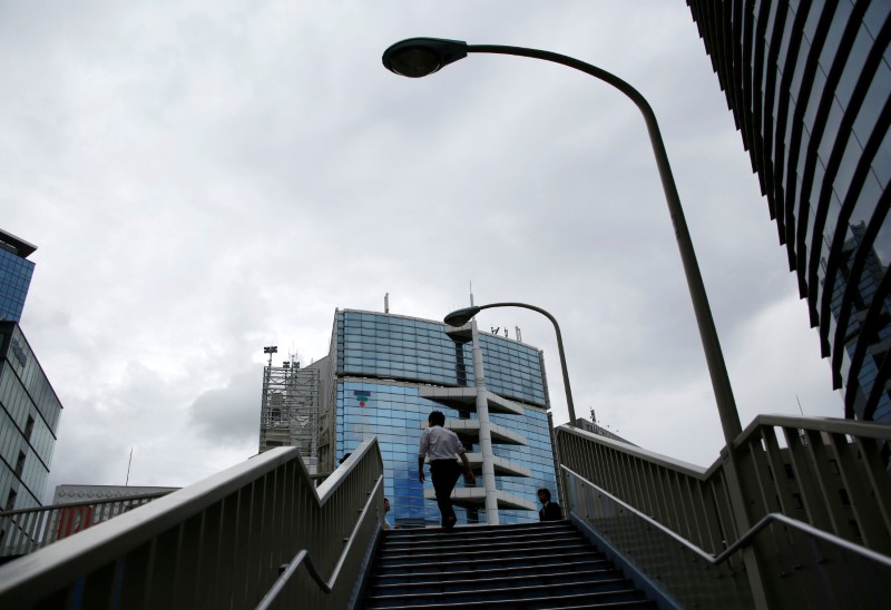 © Reuters. A man climbs the stairs to a bridge at a commercial district in Tokyo