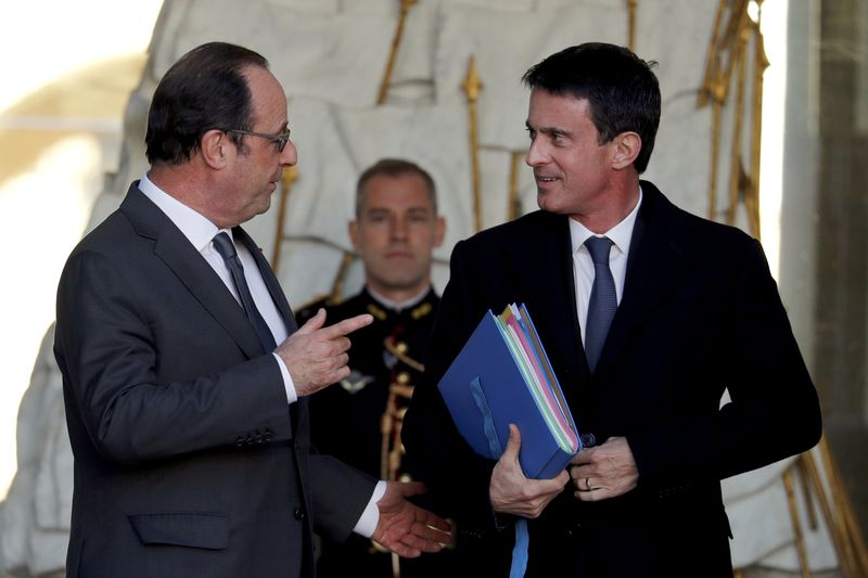 © Reuters. French President Hollande speaks with Prime Minister Valls as he leaves the Elysee Palace in Paris