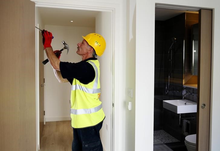 © Reuters. Carpenter Helad adjusts a door in a new apartment in Hackney