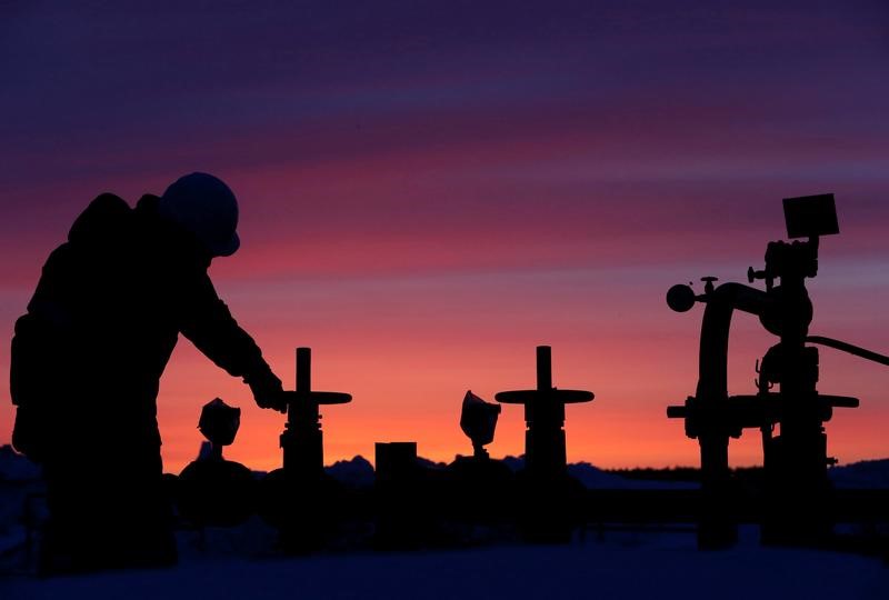 © Reuters. Worker checks valve of oil pipe at oil field owned by Bashneft company near Nikolo-Berezovka