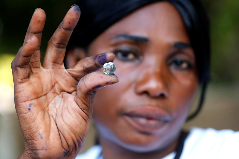 © Reuters. A poll worker holds a marble which represents one vote after the close of voting during the presidential election in Banjul