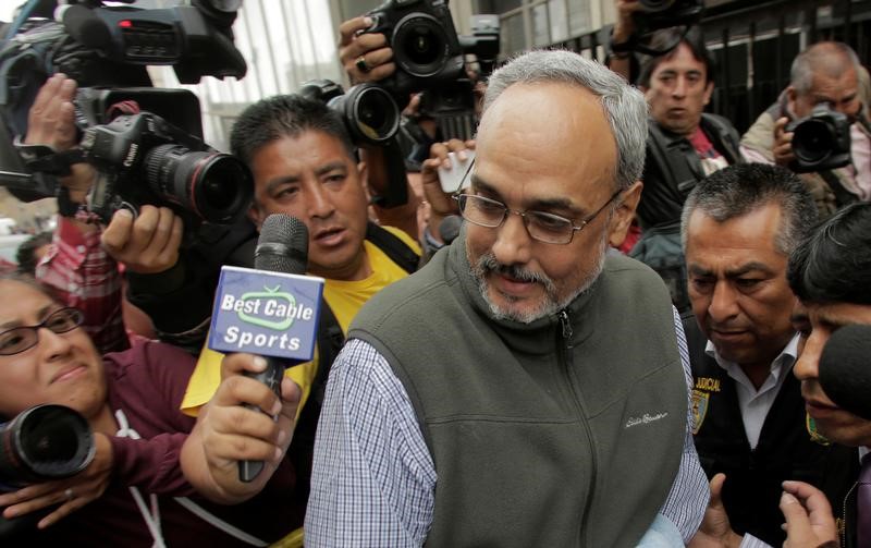 © Reuters. Former Peruvian soccer federation president Manuel Burga is escorted by police at Peru's judicial office, following his arrest in Lima