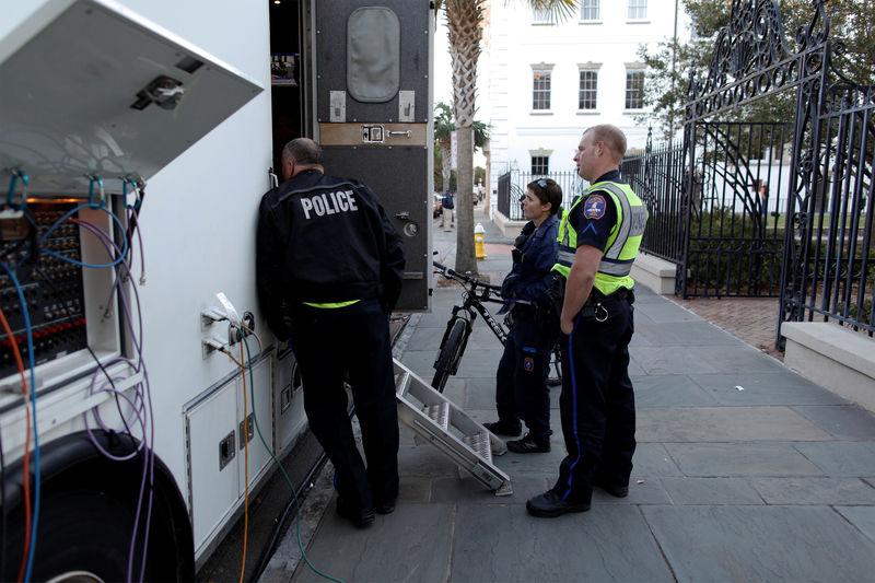 © Reuters. Charleston city police personnel listen to updates of the trial of former North Charleston police officer Michael Slager from the live feed truck in front of the Charleston County Courthouse in Charleston