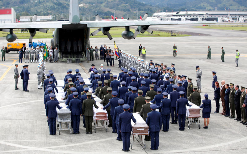 © Reuters. Military personnel unload a coffin with the remains of Brazilian victims who died in an accident of the plane that crashed into the Colombian jungle, at the airport from where the bodies will be flown home to Brazil, in Medellin