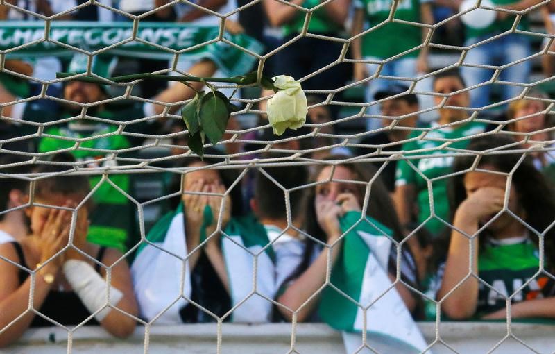 © Reuters. Una flor se ve en las redes del arco, atrás, los hinchas rinden homenaje a los jugadores fallecidos en el trágico accidente, en el Arena Conda, Chapeco