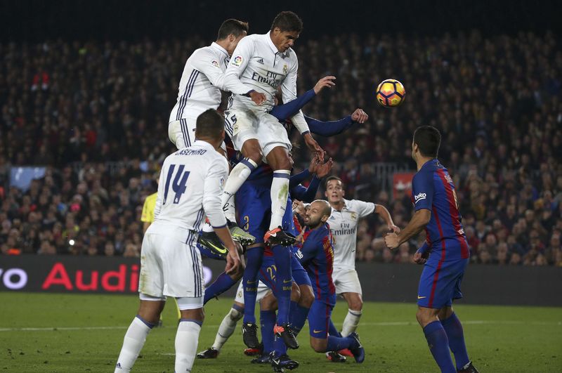 © Reuters. Cristiano Ronaldo, del Real Madrid, y Raphael Varane disputan el balón a Gerard Piqué, del Barcelona, durante el "Clásico" el sábado