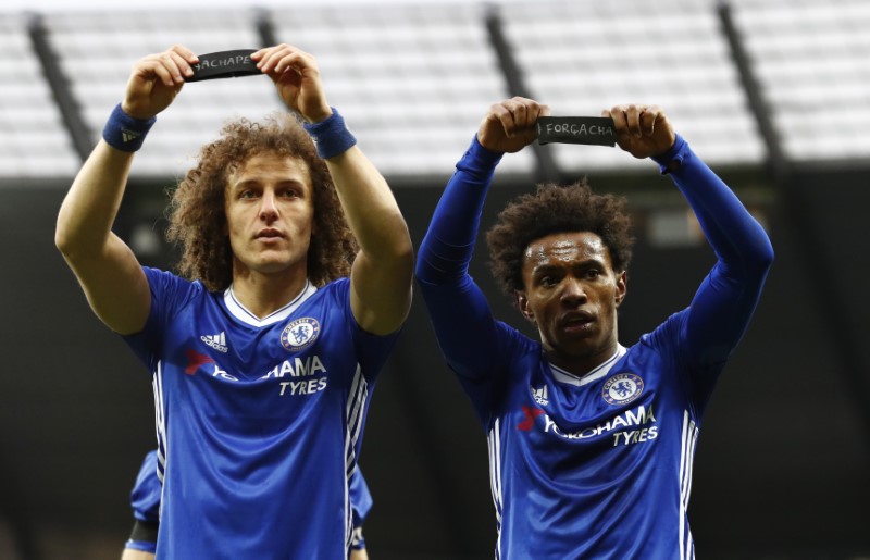 © Reuters. Chelsea's Willian celebrates scoring their second goal with David Luiz as they hold armbands in respect for the victims of the Colombia plane crash containing the Chapecoense players and staff