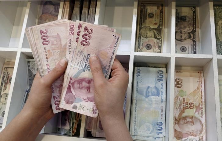 © Reuters. A money changer counts Turkish lira bills at an currency exchange office in central Istanbul, Turkey