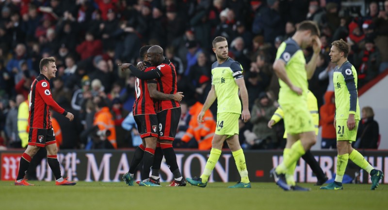 © Reuters. Bournemouth's Benik Afobe celebrates with Callum Wilson and Ryan Fraser after the game as Liverpool's Jordan Henderson and Lucas Leiva look dejected