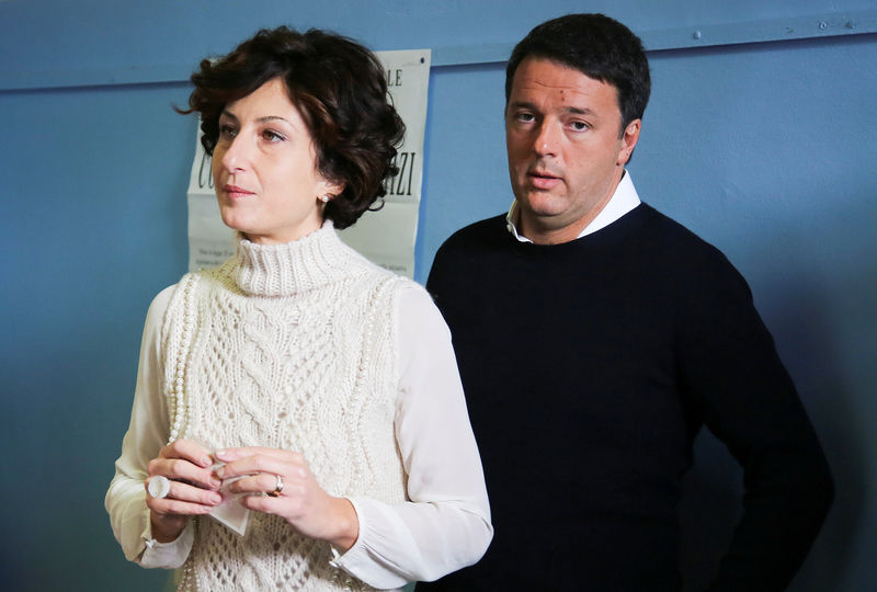 © Reuters. Italian Prime Minister Matteo Renzi and his wife Agnese wait to cast their votes for the referendum on constitutional reform, in Pontassieve