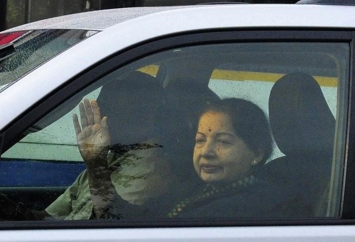 © Reuters. FILE PHOTO - Jayalalithaa waves to her supporters from a car after leaving the jail in Bangalore