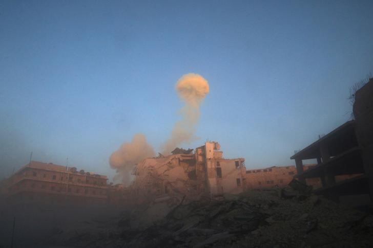 © Reuters. Smoke rises from a damaged building after a strike on the rebel-held besieged al-Shaar neighbourhood of Aleppo