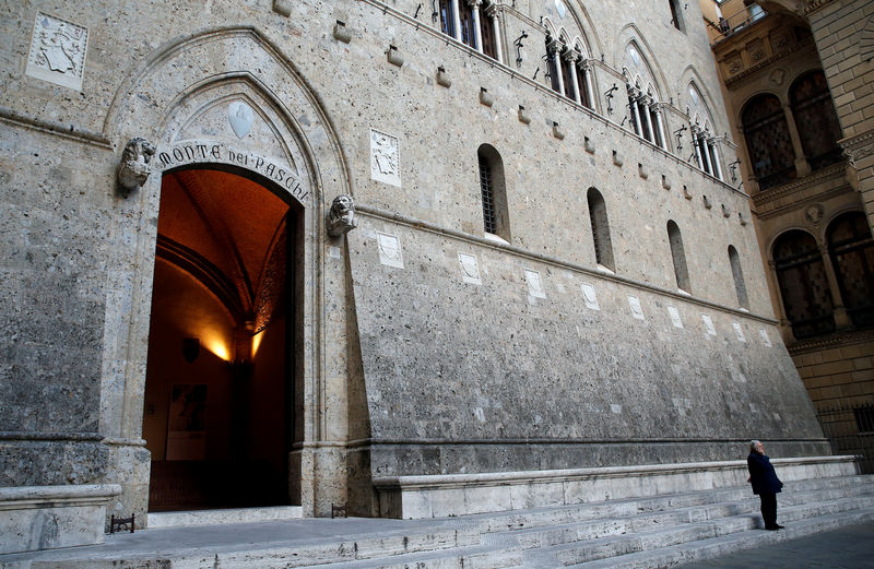 © Reuters. A man makes a phone call near the entrance of the Monte dei Paschi bank headquarters in Siena