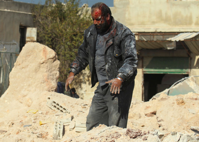 © Reuters. Homem procura por parentes em destroços após ataque aéreo na cidade síria de Idlib