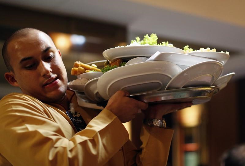 © Reuters. A waiter carries plates in 