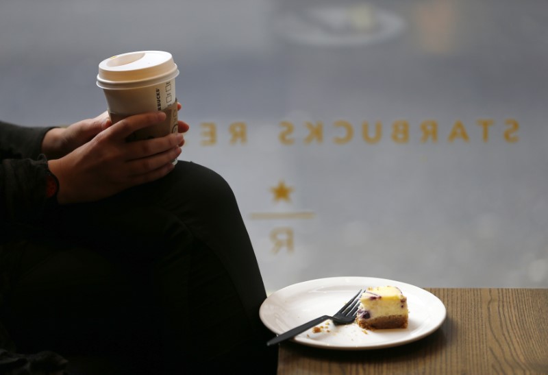 © Reuters. A customer cradles her drink in Starbucks' Mayfair Vigo Street branch in central London