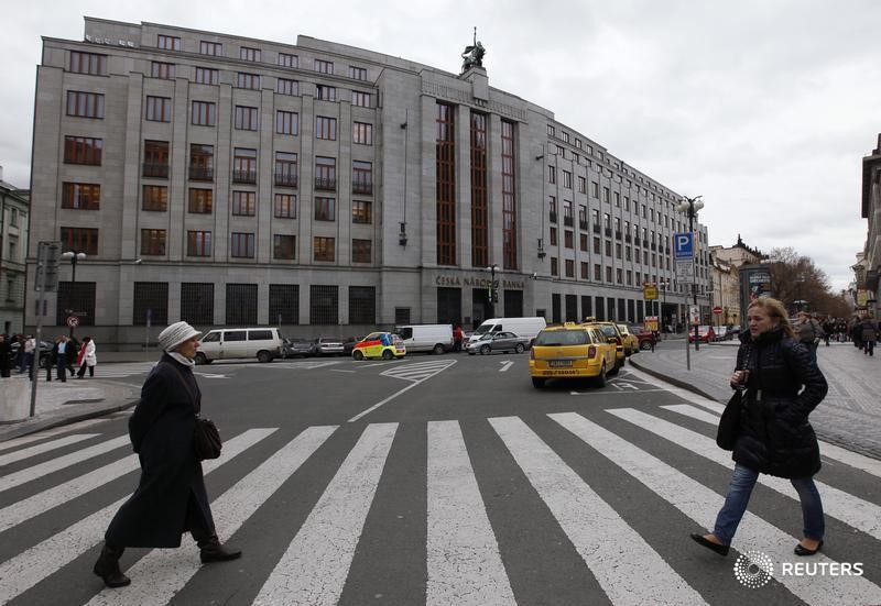 © Reuters. Two woman cross a road in front of the Czech National Bank building in central Prague