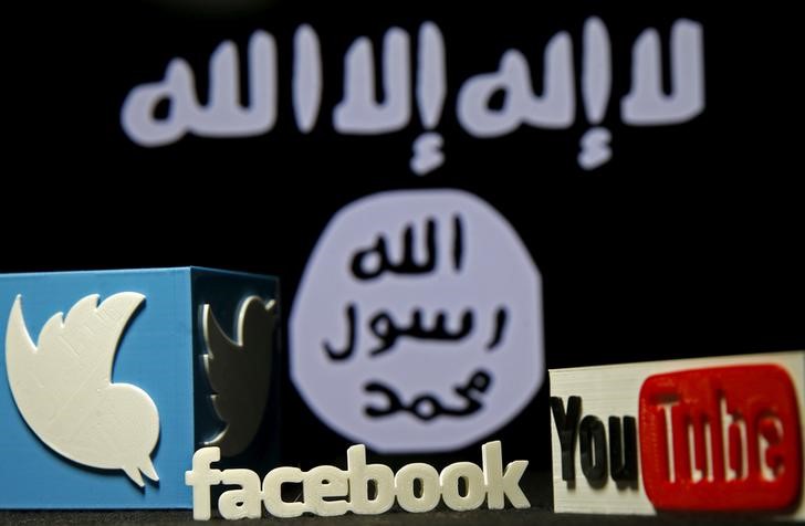 © Reuters. 3D plastic representations of the Twitter, Facebook and Youtube logos are seen in front of a displayed ISIS flag in this photo illustration