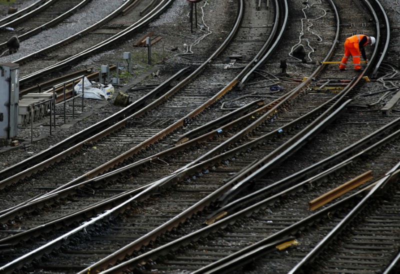 © Reuters. A worker inspects tracks on the rail lines into Victoria station in London