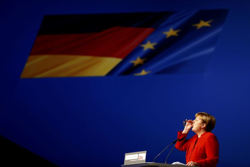 © Reuters. German Chancellor and leader of the conservative CDU Merkel drinks during her speech at the CDU party convention in Essen