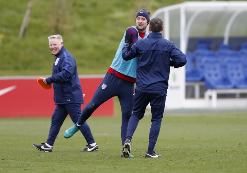 © Reuters. England's Gary Cahill and assistant coach Sammy Lee during training