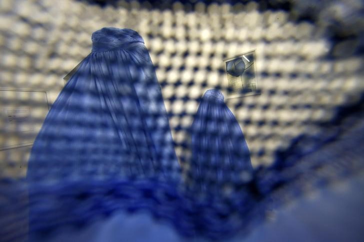 © Reuters. Visitors of the exhibition 'Burquoi' of Naneci Yurdaguel are pictured through a burka at the art gallery Nassauischer Kunstverein Wiesbaden in Wiesbaden