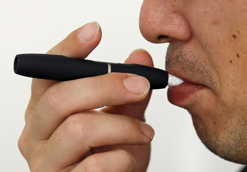 © Reuters. A customer tries a Philip Morris' "iQOS" smokeless tobacco at an iQOS store in Tokyo