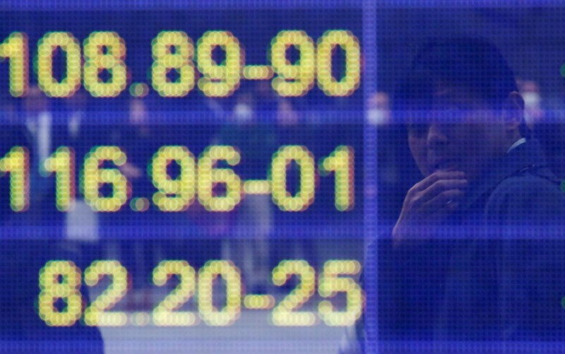 © Reuters. Man is reflected in an electronic board showing the exchange rates between the Japanese yen and the U.S. dollar, the yen against the euro, and the yen against the Australian dollar, outside a brokerage in Tokyo