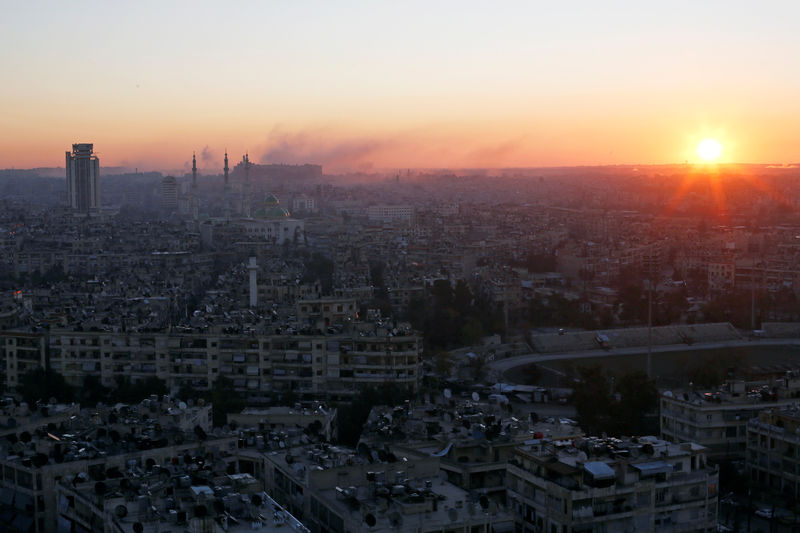 © Reuters. The sun rises while smoke is pictured near Aleppo's historic citadel, as seen from a government-controlled area of Aleppo