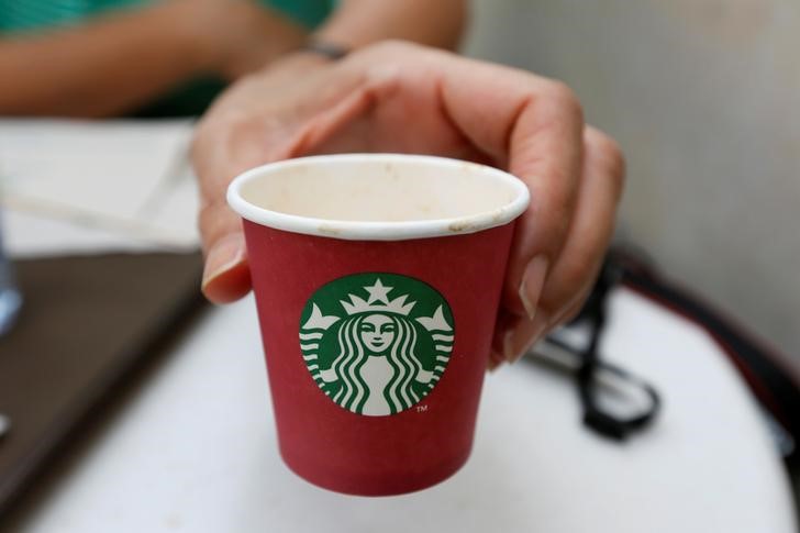 © Reuters. A woman displays a red Starbucks cup at a Starbucks cafe in Beirut