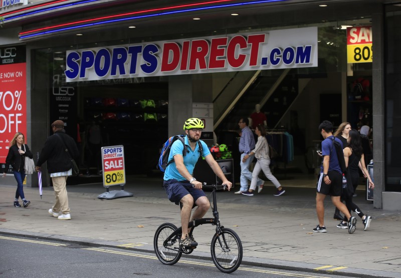 © Reuters. A man cycles past a Sports Direct store on Oxford Street in London