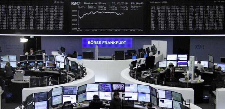 © Reuters. Traders work at their desks in front of the German share price index DAX board in Frankfurt