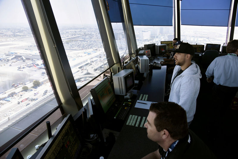 © Reuters. Air traffic controllers talk with pilots inside the control tower at Los Angeles International Airport (LAX) in  Los Angeles, California