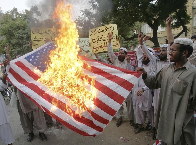 © Reuters. Activists of Jamiat Talba-e-Arabia group burn US flag during a protest in Karachi