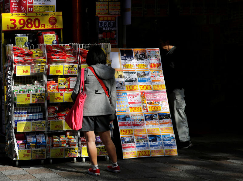 © Reuters. A woman looks at products on sale at a discount store in Tokyo's shopping district