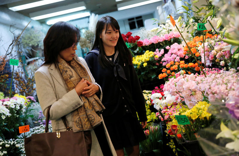 © Reuters. Chieko Shimada and her daughter Kaoruko look at flowers at a flower shop in Tokyo