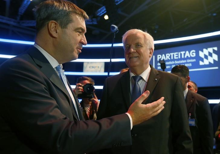 © Reuters. Bavarian Prime Minister and head of CSU Seehofer listens to Bavarian Finance Minister Soeder during CSU party congress in Munich